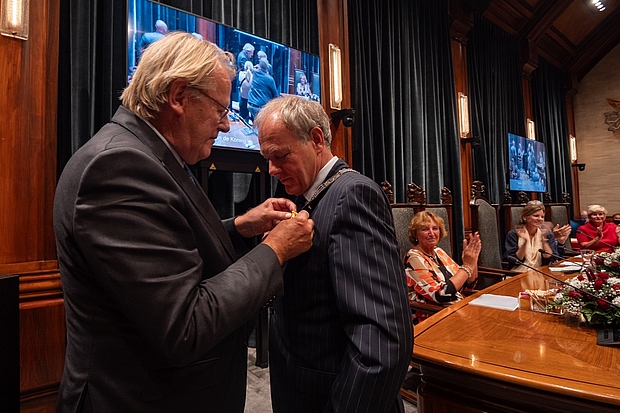 Commissaris van de Koning speld koninklijke onderscheiding op